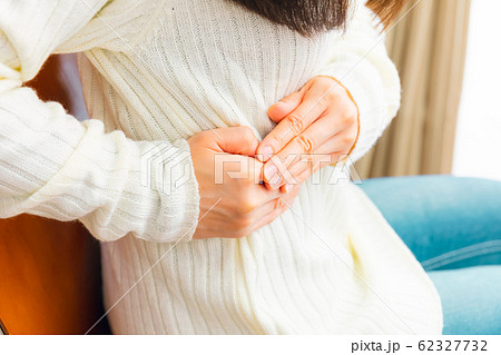 脇腹を抑える女性　様々な症状 62327732