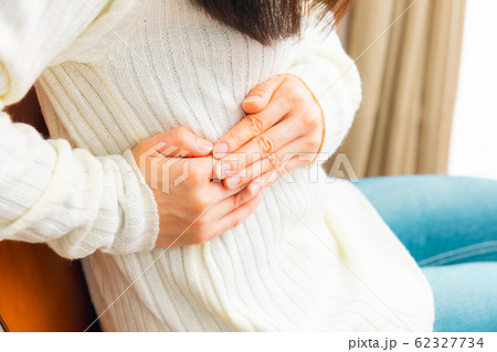 脇腹を抑える女性　様々な疾病 62327734