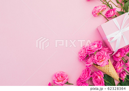 Floral frame of pink roses flowers and gift box isolated on pink background. Flat lay, Top view Floral frame of pink roses flowers and gift box isolated on pink background. Flat lay, Top view 62328364