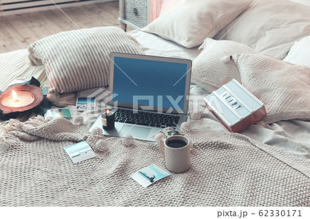 Trip photos and hot drink near laptop on bed Trip photos and hot drink near laptop on bed 62330171