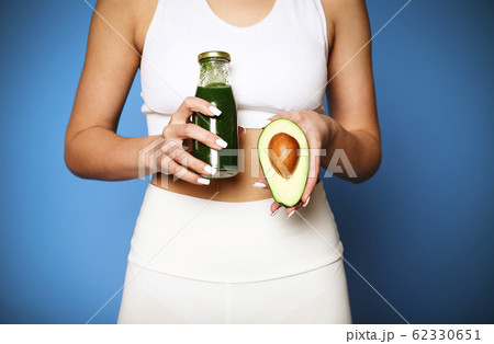 Close up of young girl holding avocado and green Close up of young girl holding avocado and green 62330651