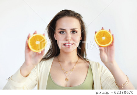 Young girl holding ripe orange isolated on light 62330670