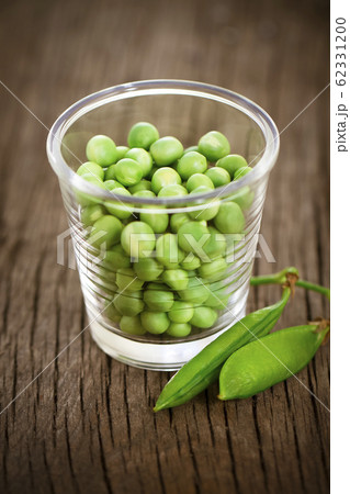 Fresh green peas in little glass on the rustic Fresh green peas in little glass on the rustic 62331200