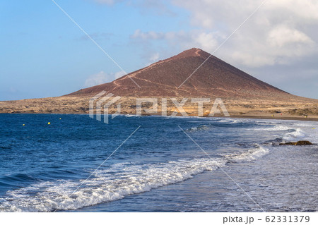 Montana Roja mountain on Tenerife coast near El Medano, Canary Islands, Spain, sunny summer day Montana Roja mountain on Tenerife coast near El Medano, Canary Islands, Spain, sunny summer day 62331379