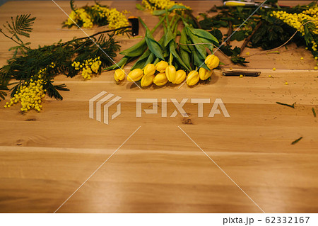Working place of floristic. Yellow tulips lilac on wooden table 62332167