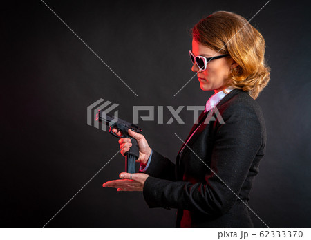 beautiful elegant woman puts bullets in the gun 62333370