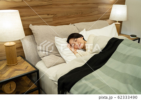ミドル女性 寝る ベットルーム 寝室 ライフスタイルイメージの写真素材