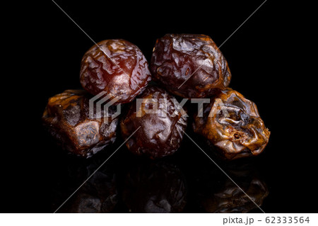 Dry brown date fruit isolated on black glass 62333564