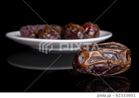 Dry brown date fruit isolated on black glass 62333601