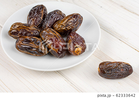 Dry brown date fruit on grey wood 62333642