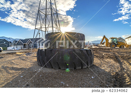 Sun in the cloudy blue sky shining brightly behind 62334062