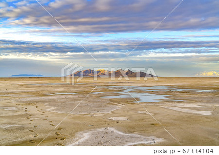 Sandy shore of a lake and distant rugged mountain Sandy shore of a lake and distant rugged mountain 62334104
