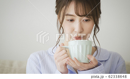 パジャマ姿でマグカップを持つ女性 パジャマ姿でマグカップを持つ女性 62338648