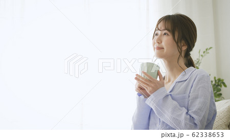 パジャマ姿でマグカップを持つ女性 パジャマ姿でマグカップを持つ女性 62338653
