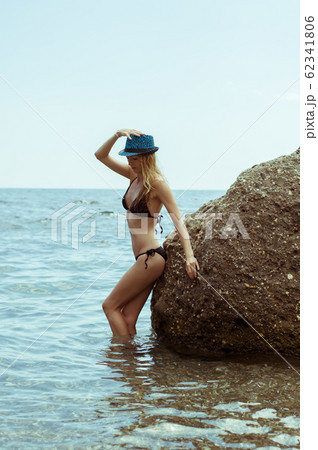 Beautiful slim young woman in a black bikini 62341806