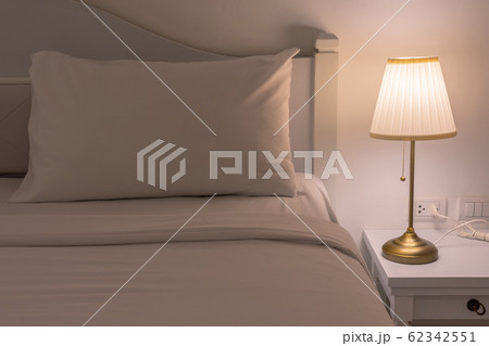 Bedside with a low energy side lamp turned on. The modern design. 62342551