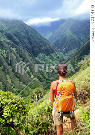 Hiker woman backpacker hiking with backpack in Hawaii mountains on Waihee ridge trail, Maui, USA. Hiker girl walking in tropical forest nature landscape 62344348