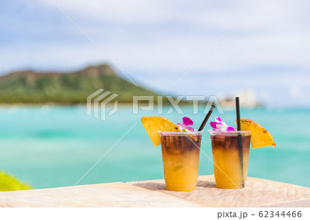 Hawaii mai tai drinks on waikiki beach bar travel vacation in Honolulu, Hawaii. Famous hawaiian drink cocktails with view of ocean and diamond head mountain, Hawaii tourist attraction Hawaii mai tai drinks on waikiki beach bar travel vacation in Honolulu, Hawaii. Famous hawaiian drink cocktails with view of ocean and diamond head mountain, Hawaii tourist attraction 62344466