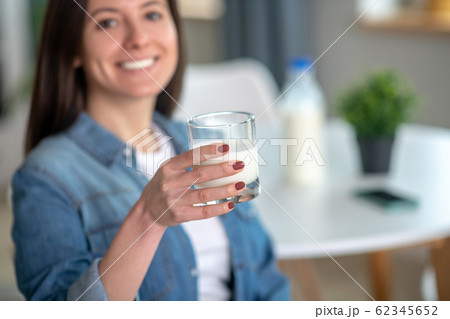 Woman holding a glass of tasty milk 62345652