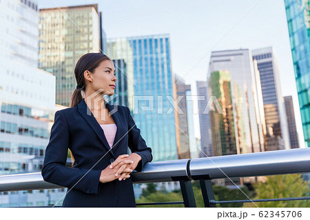 Happy business woman portrait of young female urban professional businesswoman in suit standing outside office buildings cross-armed. Happy business woman portrait of young female urban professional businesswoman in suit standing outside office buildings cross-armed. 62345706