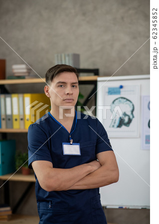 Young male doctor in dark-blue shirt looking serious 62345852