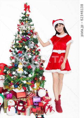 pretty girl standing by christmas tree on white 62346138