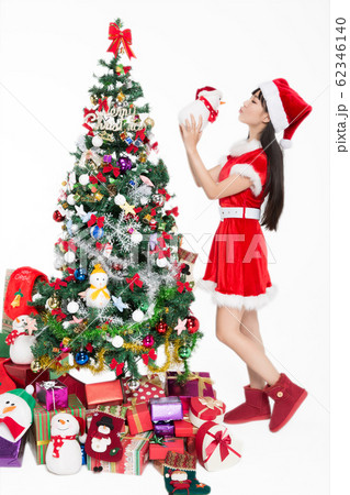 pretty girl standing by christmas tree on white 62346140