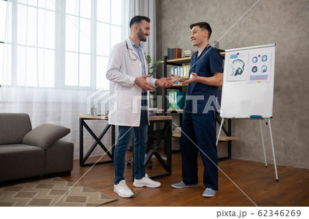 Two doctors talking during changeover and looking positive Two doctors talking during changeover and looking positive 62346269