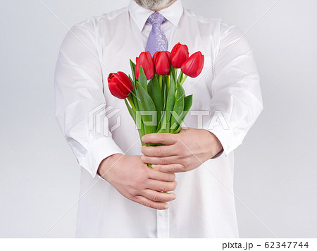 adult man in a white shirt and a lilac tie holding 62347744