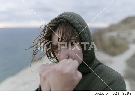 Kickboxing woman training in nature. Beautiful young woman stabs at the camera, looking at the camera. Confident, independent girl in sportswear and a hoody Kickboxing woman training in nature. Beautiful young woman stabs at the camera, looking at the camera. Confident, independent girl in sportswear and a hoody 62348298