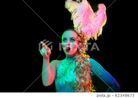 Beautiful young woman in carnival and masquerade costume in colorful neon lights on black background Beautiful young woman in carnival and masquerade costume in colorful neon lights on black background 62348673