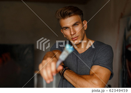 Young handsome man artist with brush in hand Young handsome man artist with brush in hand 62349459