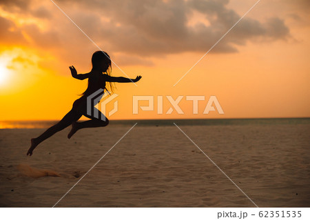 Adorable happy little girl on white beach at sunset. Adorable happy little girl on white beach at sunset. 62351535