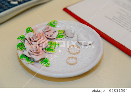 Gold wedding rings on a decorated plate. Gold wedding rings on a decorated plate. 62351594