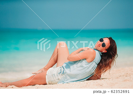 Woman laying on the beach enjoying summer holidays looking at the sea Woman laying on the beach enjoying summer holidays looking at the sea 62352691