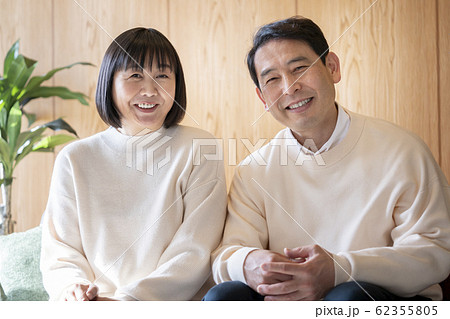 並んでソファに座る50代後半の夫婦　　 62355805