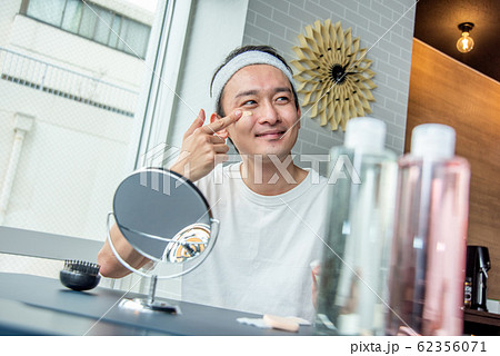 化粧男子　お肌に気を使ってファンデーションを塗る男性 62356071