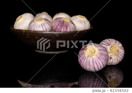 Single clove garlic isolated on black glass 62356502