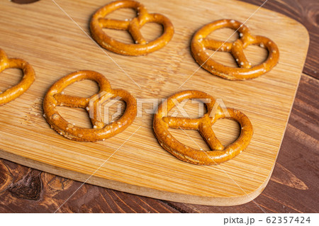 Salty brown pretzel on brown wood Salty brown pretzel on brown wood 62357424