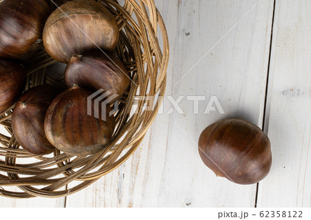 Brown edible chestnut on grey wood 62358122