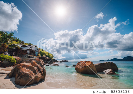 Anse Takamaka beach, Seychelles. Hotel on the beach, nun sun burst light over the ocean horizon 62358158