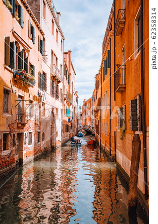 Venice, Italy. Beautiful view of the typical channels canals in Venezia. With small boat and Gondolas transportation Venice, Italy. Beautiful view of the typical channels canals in Venezia. With small boat and Gondolas transportation 62358314