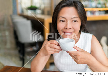 Mature Asian woman drinking english breakfast tea relaxing at cafe. Chinese middle-aged lady enjoying city lifestyle, stylish living 62361121