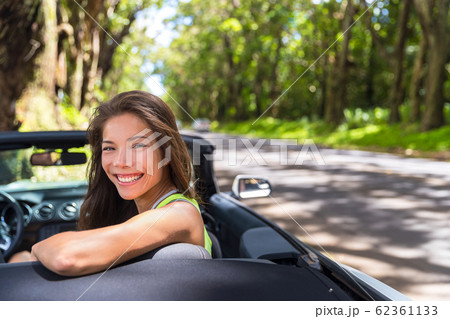 Happy young Asian woman relaxing in convertible car on summer road trip vacation. Travel destination driving through nature roads 62361133
