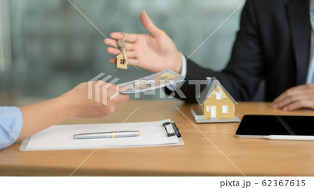 Cropped shot of real estate agent giving house key Cropped shot of real estate agent giving house key 62367615