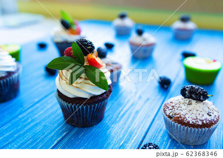 Freshly baked sweet muffins on a blue background. Freshly baked sweet muffins on a blue background. 62368346