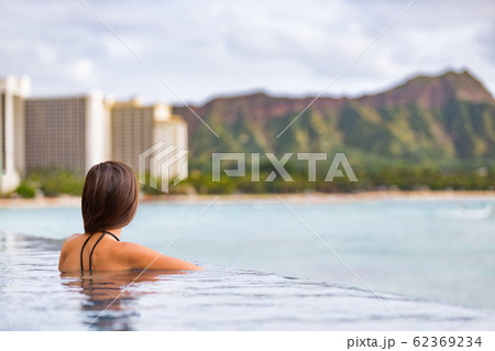 Hawaii vacation Honolulu travel tourist woman relaxing in swimming infinity pool at luxury resort hotel in Waikiki beach, watching sunset. Girl on USA summer travel landscape banner panoramic 62369234