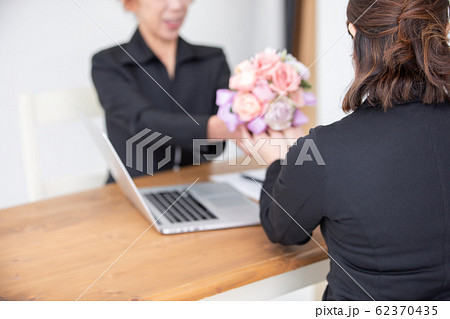 花束を渡す女性スタッフ 62370435