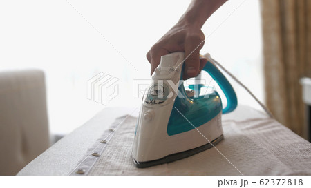 Close up of male hands ironing clothes with iron on an ironing board. slow motion 62372818