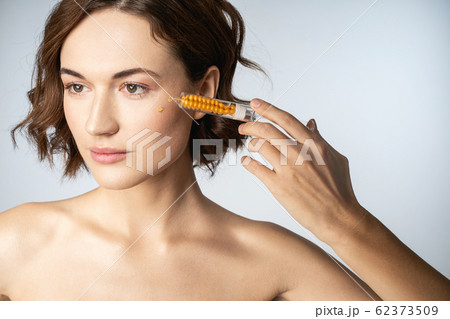 Close up of young woman that using hyaluronic acid Close up of young woman that using hyaluronic acid 62373509